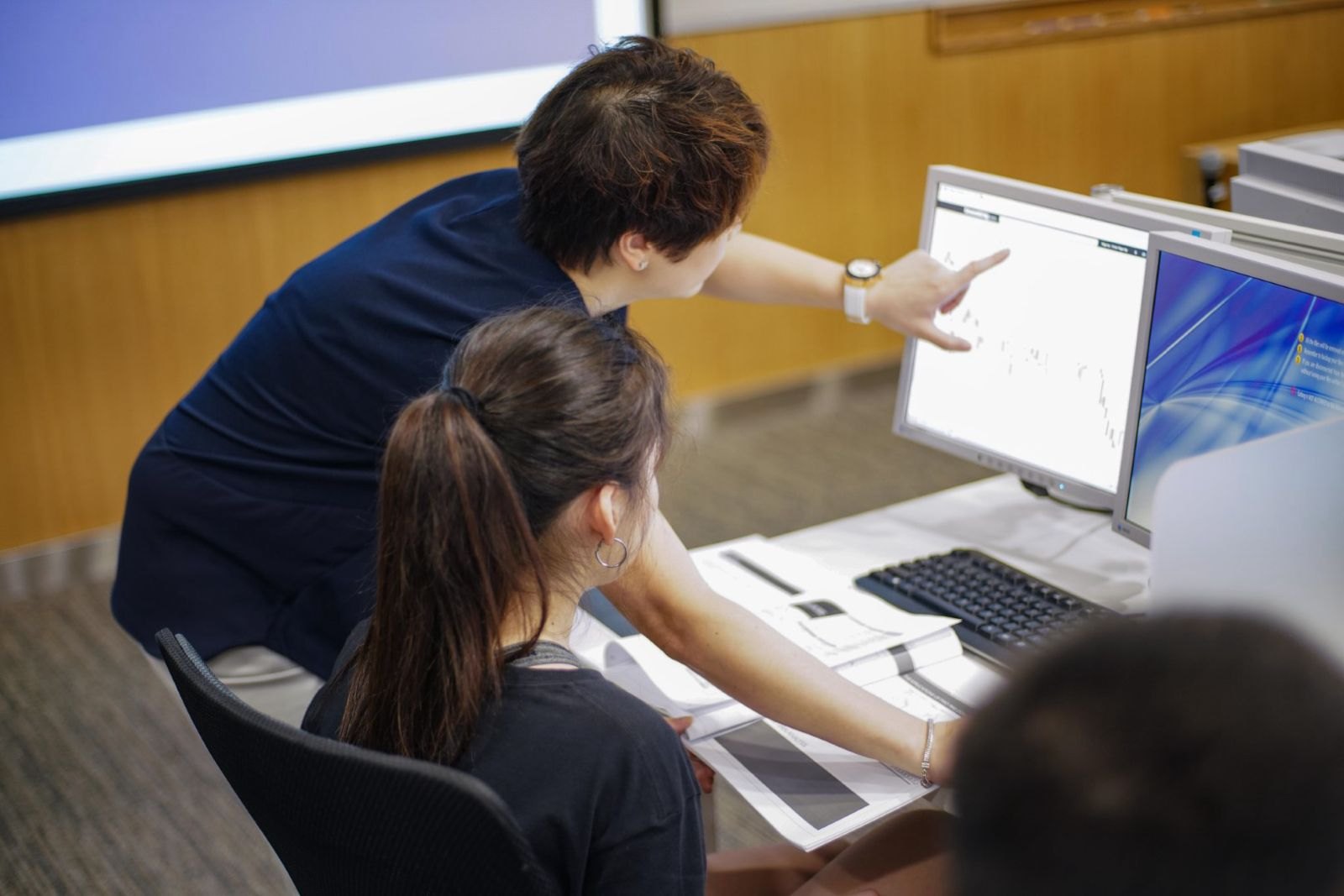 Instructor guiding a student through market analysis