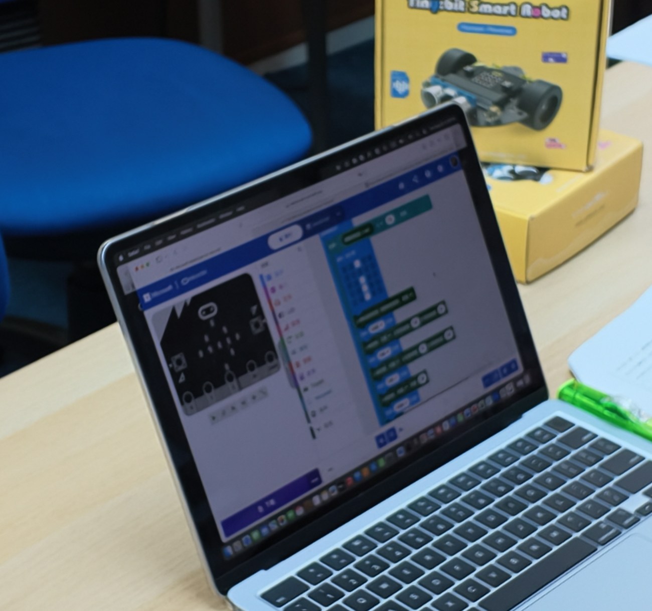 A student’s robot-car code in the MakeCode editor beside the micro:bit kit at the NextGen AI trial class